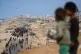 Displaced Palestinians gather on the coastal road near Wadi Gaza, as Israeli tanks block the road leading to Gaza City, in the central Gaza Strip, October 9, 2025