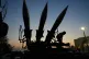 A boy tries to stand near missiles displayed in the National Aerospace Park of the Revolutionary Guard, just outside Tehran, Iran, November 13, 2025