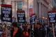 Protesters march past the Milken Center for Advancing the American Dream, during a 