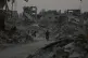 Displaced Palestinians walk among the ruins of destroyed buildings in Khan Younis, Gaza Strip, November 8, 2025