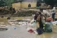 People use flood water to remove mud from clothing at a village hit by a flash flood in Batang Toru, North Sumatra, Indonesia, November 29, 2025