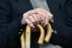 An elderly man holding a walking stick
