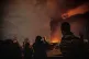 Residents look on and take pictures as flames and smoke rise from an oil storage facility struck as attacks hit the city during the U.S.–Israeli military campaign in Tehran, Iran, March 7, 2026
