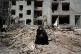 A woman sits on rubble across from a residential building damaged last Sunday during the US-Israeli air strikes on Tehran, Iran, March 12, 2026