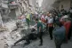First responders inspect a destroyed car at the site of a residential building hit in an overnight strike during the U.S.-Israeli military campaign in Tabriz, East Azerbaijan Province, northwestern Iran, March 24, 2026