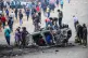 People strip parts from a burned-out vehicle during a public transport strike over fuel prices in Nairobi, Kenya, May 18, 2026