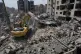 Rescue workers use an excavator, as they search for victims under the rubble of a building that was hit Monday in an Israeli airstrike in the southern port city of Tyre, Lebanon, June 2, 2026