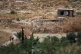 Two boys walk along a road near a damaged building in the village of Abdin, Daraa province, Syria, June 29, 2026, after local residents said Israeli forces carried out an incursion into the area a day earlier