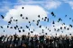 Year 11 pupils throw their mortarboards into the air following a graduation ceremony on their last day of school at BBG Academy in Bradford, June 11, 2021