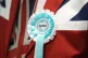 A man in a Union Jack blazer sports a Reform UK rosette