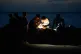 A man repairs a guitar string by the light of a flashlight on the Malecon seawall during a blackout in Havana, Cuba, July 14, 2026
