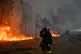 A firefighter gestures next to burning trees as a wildfire rages near Marcheprime, outside, Bordeaux, France, July 26, 2026