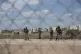 Israeli soldiers stand guard near a damaged section of the I