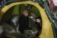 A woman sits with her children inside the tent at the 