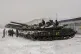 Ukrainian soldiers examine their tanks at a military unit cl