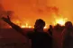 People react as they try to extinguish a wildfire in Avantas