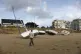 A man walks by washed ashore boats on the beach of Pornichet