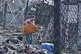 An asylum-seeker collects his belongings after a fire broke 
