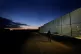 A man walks by the fence at the Pournara migrant reception c
