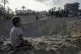Palestinians look at the destruction after an Israeli airstr