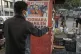 A man hangs a poster with a photo of presidential candidate 