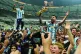 Argentina's Lionel Messi celebrates with the trophy in front