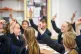 Students raise their hands in class at Royal High School Bat