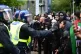 Police officers stand in front of protesters in Kensington, 
