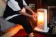 An elderly lady with an electric fire on at home