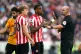 Referee Robert Madley (right) asks Brentford players to step