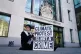 A protester sits outside Westminster Magistrates' Court, Lon