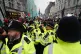 Police officers watch as people take part in a national marc