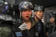 A wounded police officer is helped by colleagues after clash